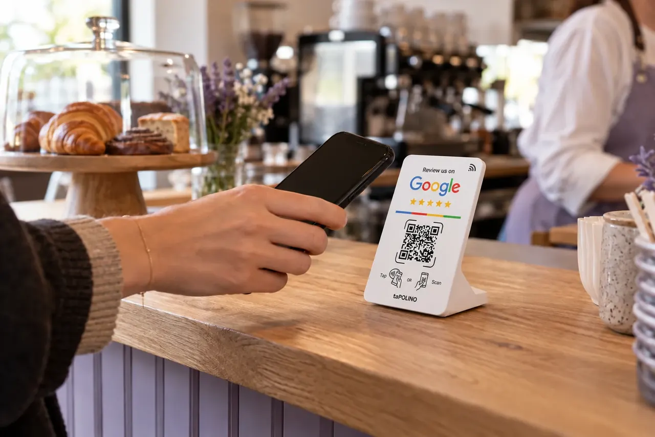 Weißes taPOLINO-Schild auf einem Café-Tresen, ein Gast hält sein Handy daran